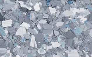 Close-up of a terrazzo flooring surface with irregular gray, white, and blue stone chips set in a neutral background.